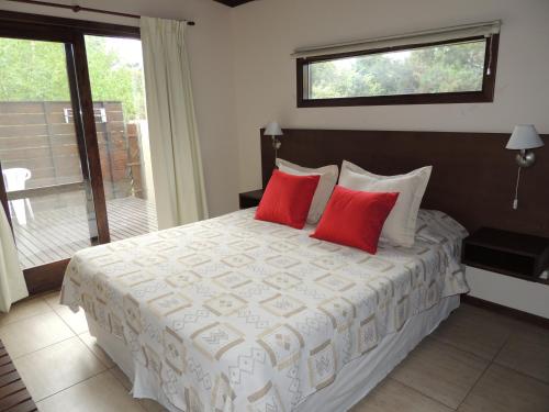 马德普拉塔克利彭山林小屋的一间卧室配有一张大床和两个红色枕头