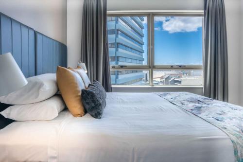 悉尼Central 1-Bed with Parking, Pool, Sauna & Gym的一间卧室设有一张大床和大窗户