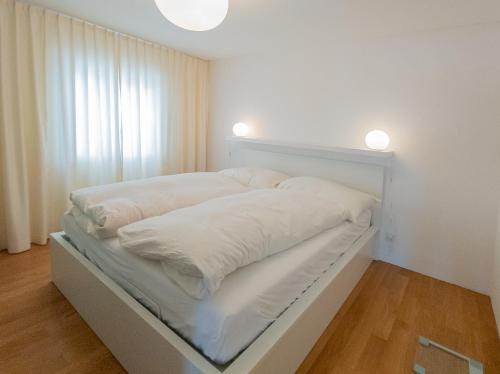 切勒里纳Apartment Chalchera的一间卧室配有白色床单和灯。