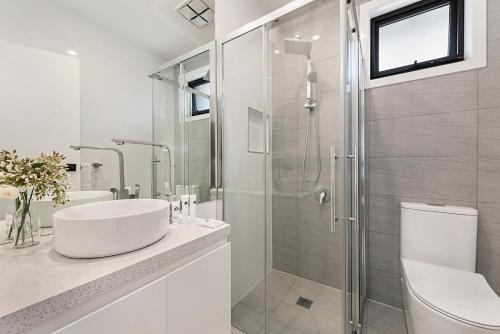 CarnegieGorgeous 3-Bed House with Spacious Shared Backyard的白色的浴室设有水槽和淋浴。