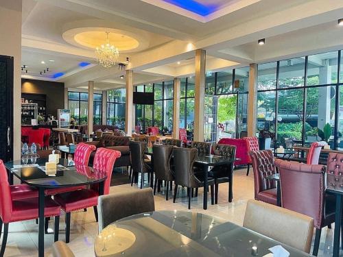 莱卡邦Pongsakorn Boutique Resort -SHA Extra Plus的餐厅设有桌椅和窗户。
