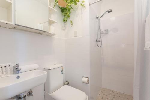悉尼Comfy Balcony Studio near Parks, Shopping & Dining的白色的浴室设有卫生间和淋浴。
