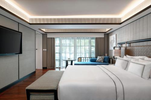 曾蒙海滩Melia Koh Samui的酒店客房设有一张大床和一台电视。