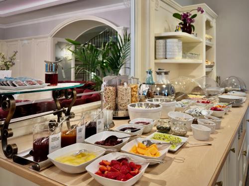梅拉诺Windsor Merano Hotel & Suites的自助餐,在柜台上提供许多碗食物