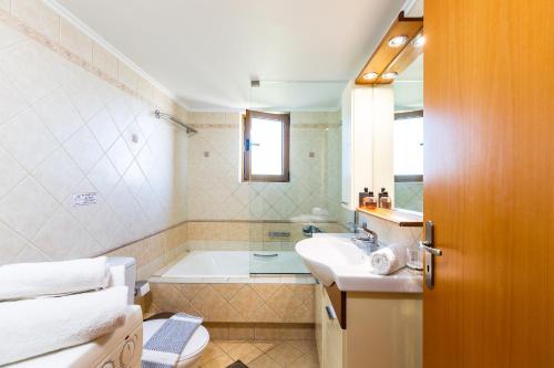 马鲁拉斯Maroulas Villas Ioanna & Stavros, stunning views, By ThinkVilla的带浴缸、盥洗盆和卫生间的浴室