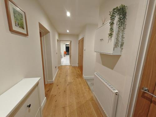 温彻斯特Little Hampden的走廊设有白色墙壁和木地板