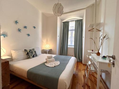 里斯本262 Baixa Guesthouse的卧室配有一张床和一张书桌,墙上有鸟儿