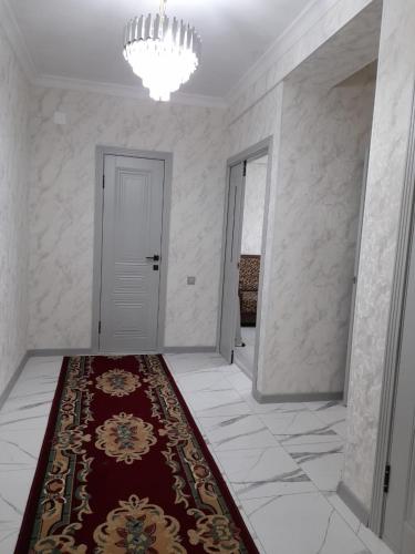 奥什Apartment 2хкомнатрая квартира的一条有红色地毯和白色门的走廊