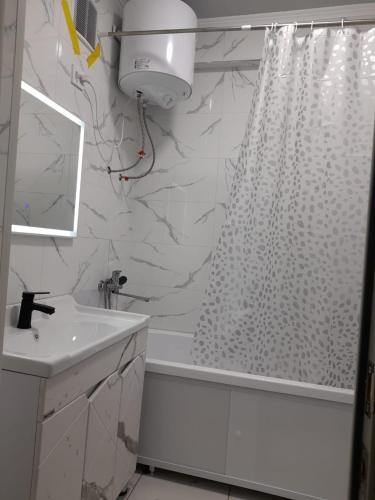 奥什Apartment 2хкомнатрая квартира的浴室设有白色的淋浴帘和水槽