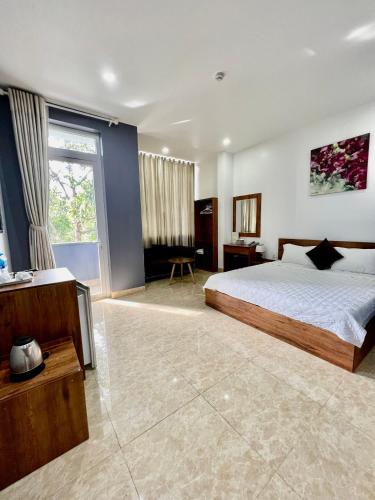 邦美蜀Khách Sạn Trung Anh 78 HAI BÀ TRƯNG BMT的一间卧室设有一张床和一个大窗户