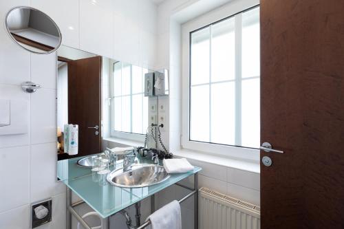 腓特烈港Select Hotel Friedrichshafen的一间带两个盥洗盆和窗户的浴室