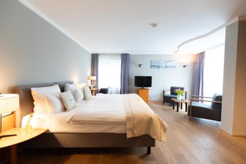 腓特烈港Select Hotel Friedrichshafen的一间带大床的卧室和一间客厅