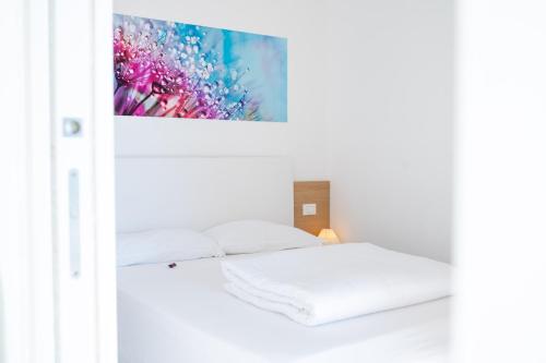 内图诺I Bordin Home的白色的房间,配有一张床和墙上的绘画