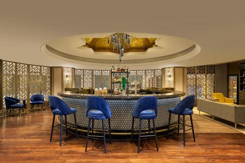 吉隆坡吉隆坡喜来登帝国酒店的大堂设有带蓝色凳子的酒吧
