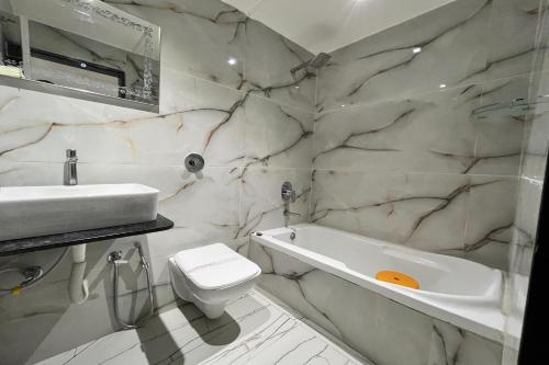 艾哈迈达巴德HOTEL SHAILLY INN的一间带水槽、浴缸和卫生间的浴室