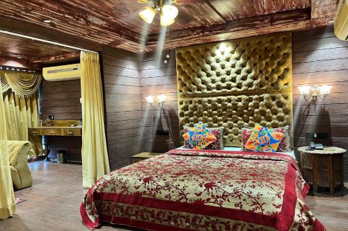 艾哈迈达巴德HOTEL SHAILLY INN的一间卧室设有一张大床和木墙