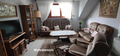 阿尔夫Ferienwohnung Katharina I的客厅配有两把椅子和电视