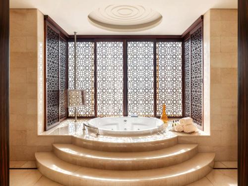迪拜迪拜莱福士酒店的窗户前设有带浴缸的浴室