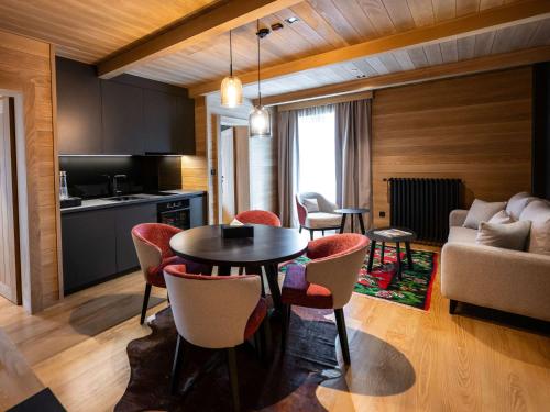 科拉欣Swissôtel Resort Kolasin的厨房以及带桌椅的起居室。