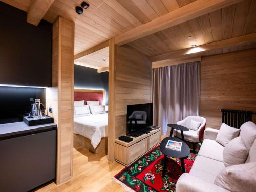 科拉欣Swissôtel Resort Kolasin的酒店客房,配有床和沙发