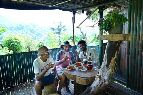 PadakaluHarakoppa Hills的一群坐在餐桌上吃食物的男人