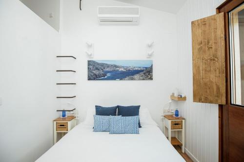 卡达克斯赫斯塔勒特卡达克斯酒店的一间卧室配有带白色床单和蓝色枕头的床。
