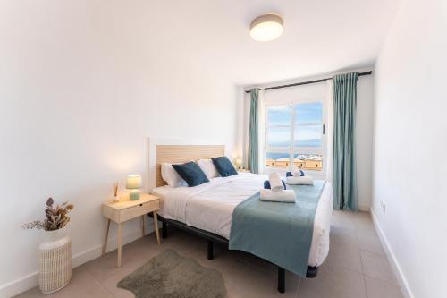 卡亚俄萨尔瓦赫Callao sunset apartment, sea view and pool的一间卧室设有一张床和一个大窗户