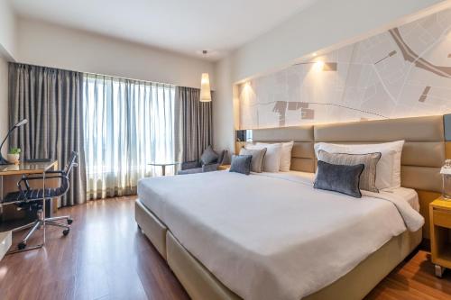 孟买戈尔甘费恩酒店的酒店客房设有一张大床和一张书桌。