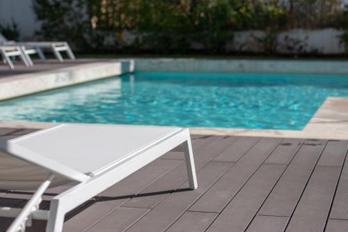 埃武拉埃武拉橄榄酒店的游泳池旁的白色长凳