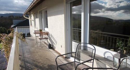 巴哈拉赫Ferienwohnung mit Balkon und Rheinblick的阳台,带椅子和大窗户