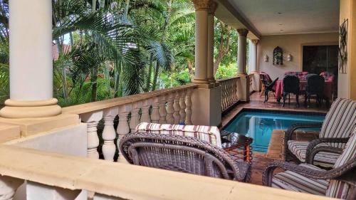 绍斯布鲁姆Casa Alegre Guesthouse的一个带椅子的门廊和一个游泳池