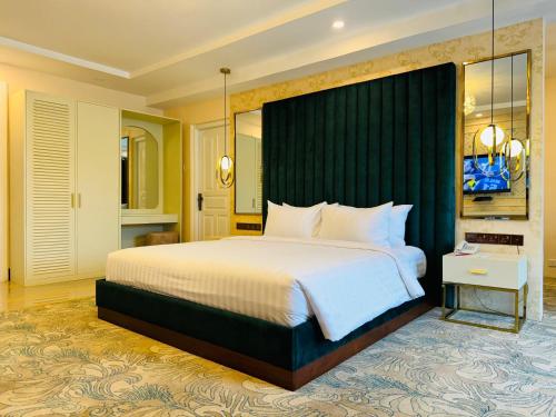 康提Devon Rest的一间卧室配有一张大床和绿色床头板