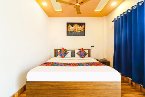 NaksalbāriFabHotel Roadside Inn的一间卧室配有一张带蓝色窗帘的大床