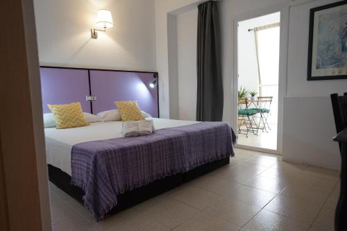 埃尔阿雷纳尔泰德酒店的一间卧室配有一张大床和紫色毯子