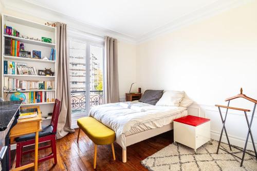 巴黎GuestReady - Estadia maravilhosa perto do Père-Lachaise的一间卧室配有一张床、一张书桌和一个窗户。