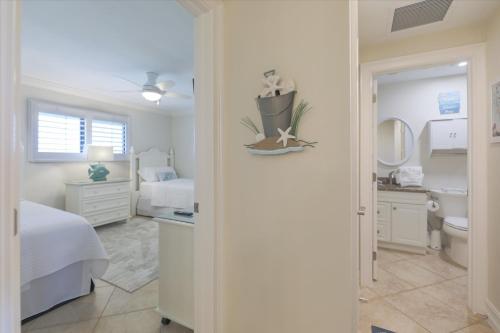 萨尼贝尔SANDPIPER BEACH 205的一间白色卧室,配有床和一间浴室