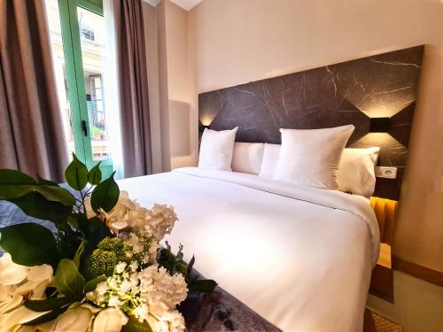 巴塞罗那Hotel Casa Gardenia的酒店客房的床铺配有白色床单和鲜花