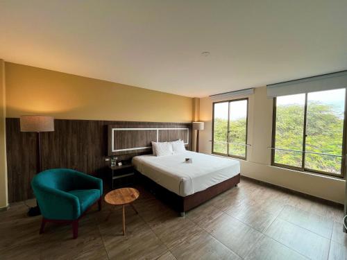 特鲁希略Rado Hotel - Quintanas的一间卧室配有一张床和一张蓝色椅子