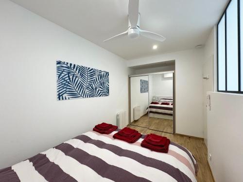 滨海卡瓦莱尔Appartement 1ch avec terrasse et jardinet à 400m de la plage的一间卧室配有一张带红色毛巾的床