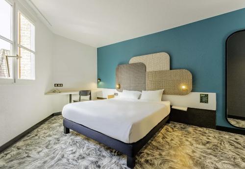 阿拉斯B&B HOTEL Arras Centre Les Places的一间卧室设有一张大床和蓝色的墙壁