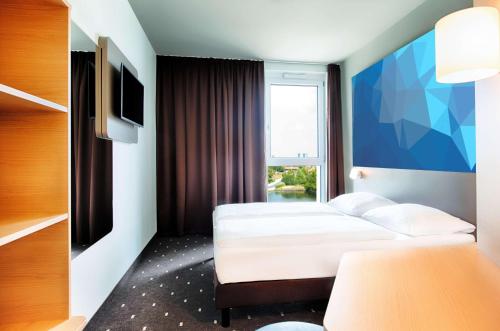 维也纳B&B HOTEL Wien-St-Marx的酒店客房设有两张床和窗户。