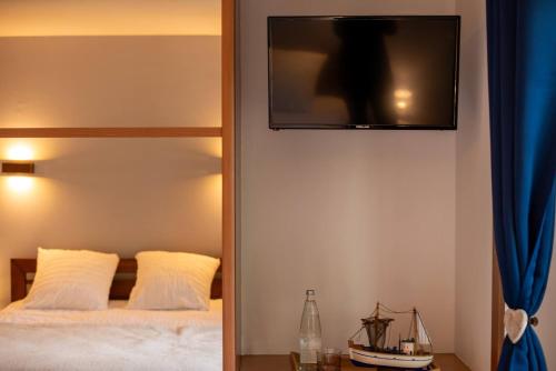 玛根塞尔Sechex Nous的卧室配有一张床,墙上配有电视。