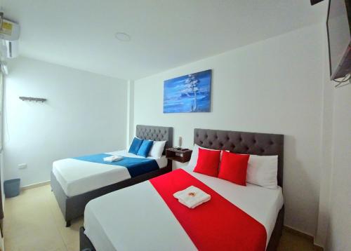 里奥阿查ANAJIRAWAA HOTEL的一间卧室配有两张带红色和蓝色枕头的床