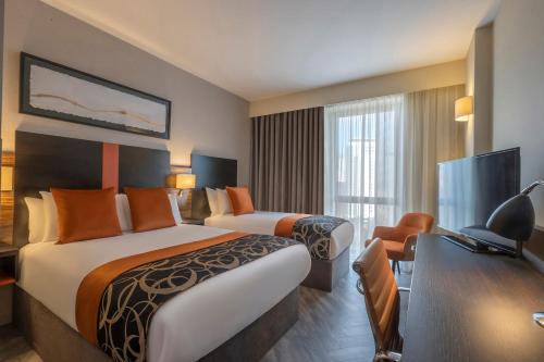 卡迪夫卡迪夫克莱顿酒店的酒店客房配有两张床和一张书桌