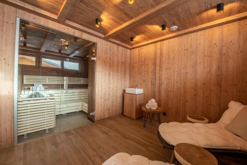 克里姆尔Filzstein Resort Haupthaus - Zillertal Arena, Hohe Tauern, Salzburgerland, Krimml, Hochkrimml的客厅设有木墙和沙发