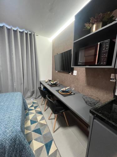 里约热内卢Studio America Gardens的客房设有一张床和一张带微波炉的书桌