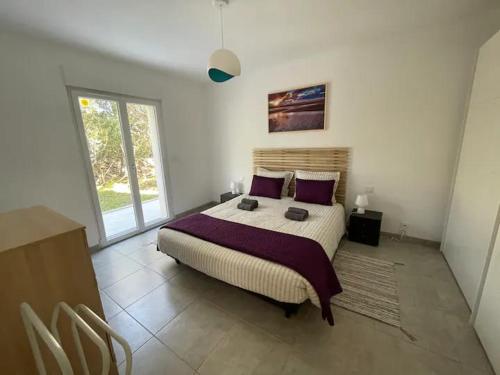 菲加里Casa Sognu di Orizonte的一间卧室配有一张带紫色枕头的大床