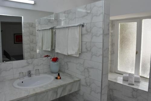 阿加迪尔塔贾德特公寓式酒店的白色的浴室设有水槽和镜子