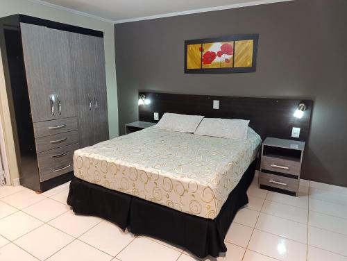 伊瓜苏港伊瓜苏阿尔图斯酒店的一间卧室设有一张大床和两个床头柜
