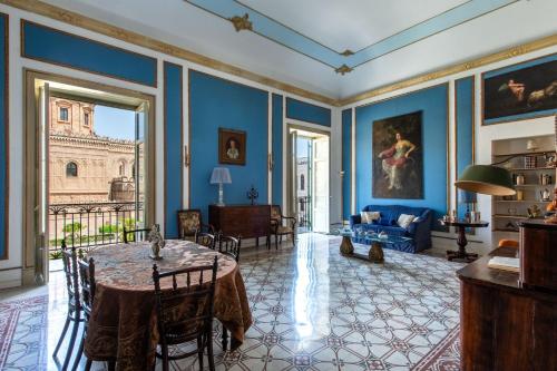 巴勒莫Cathedral View Apartments的客厅拥有蓝色的墙壁和桌椅